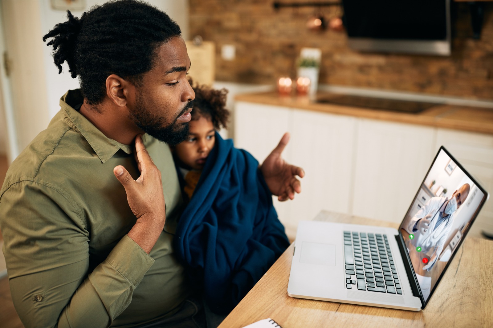 Black American doctor holding tablet with patient on screen